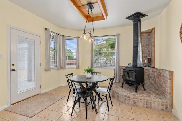 tiled dining space with a wood stove and a chandelier