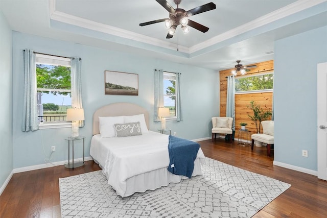 bedroom featuring ceiling fan, a raised ceiling, and ornamental molding