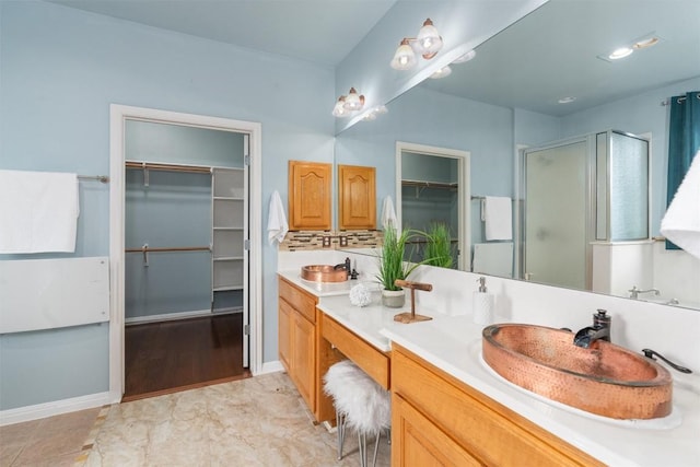 bathroom featuring vanity, backsplash, and a shower with door