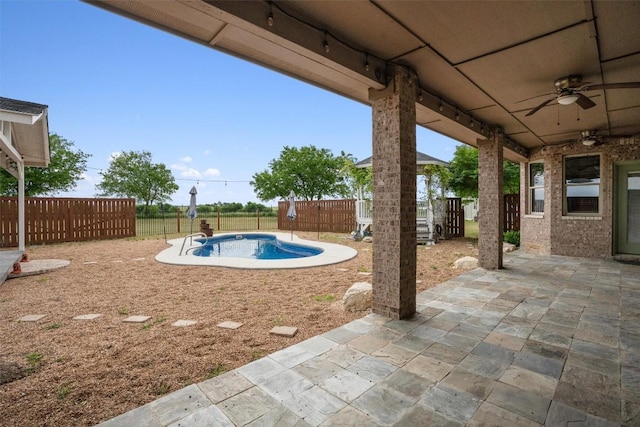 exterior space featuring a fenced in pool and ceiling fan