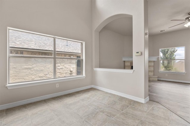 tiled spare room featuring ceiling fan