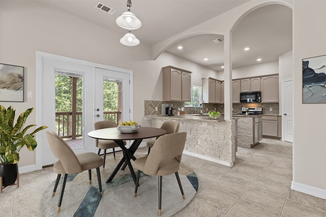 dining area with light tile patterned flooring, sink, and french doors