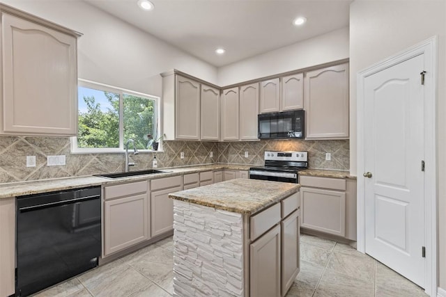 kitchen with light stone counters, gray cabinetry, sink, black appliances, and a center island