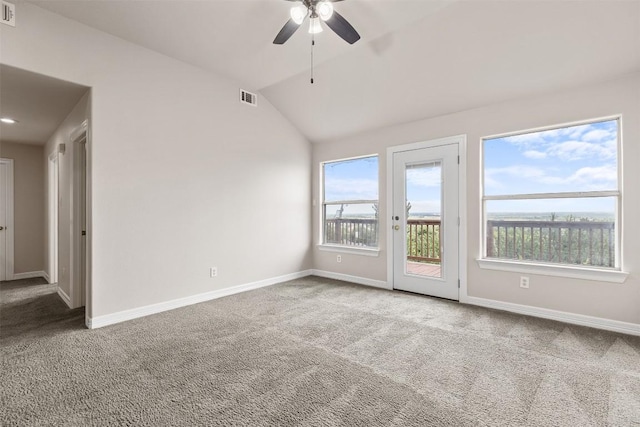 spare room with a wealth of natural light, carpet floors, lofted ceiling, and ceiling fan