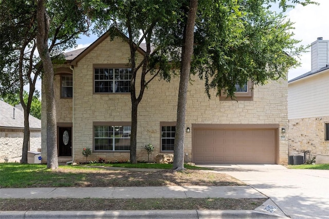 view of front of home with a garage and central AC