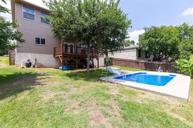 view of swimming pool with a water slide, a wooden deck, and a lawn