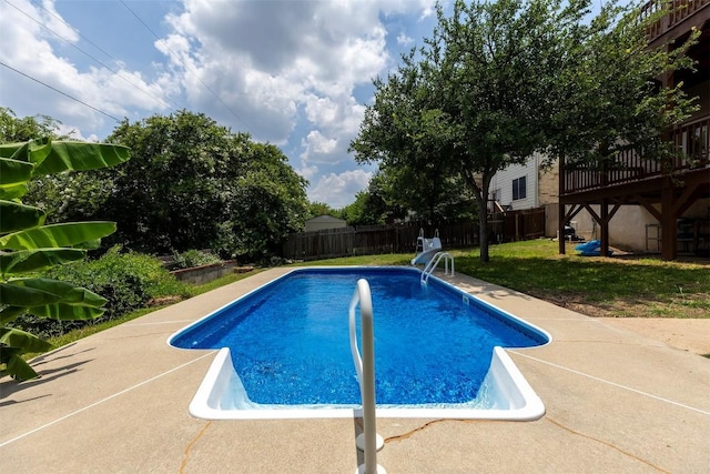 view of swimming pool featuring a lawn and a wooden deck