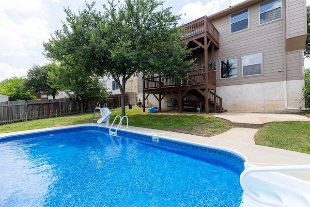 view of pool with a lawn and a wooden deck