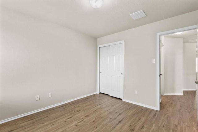 unfurnished bedroom with light hardwood / wood-style floors and a closet