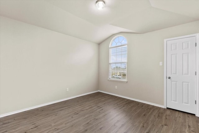 empty room featuring lofted ceiling and dark wood-type flooring