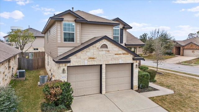 view of front of property featuring cooling unit, a garage, and a front lawn