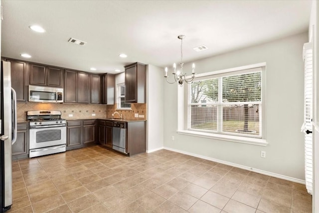 kitchen featuring sink, decorative light fixtures, a notable chandelier, dark brown cabinetry, and stainless steel appliances