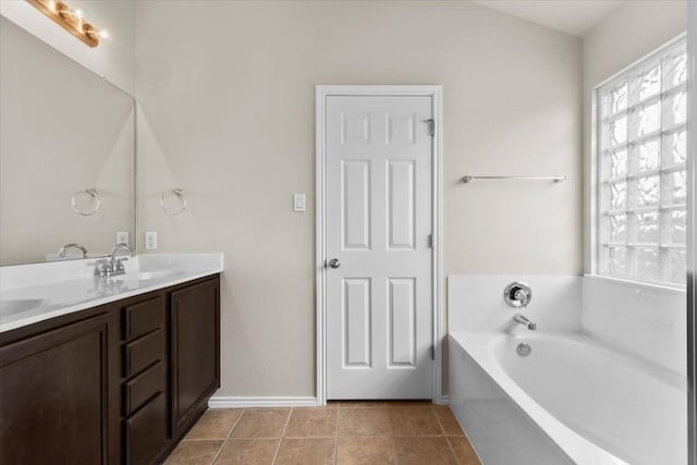 bathroom with tile patterned flooring, vanity, and a tub