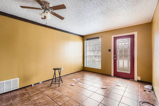 tiled entryway featuring ceiling fan and a textured ceiling