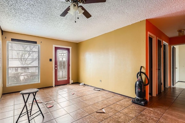 tiled entrance foyer featuring ceiling fan and a textured ceiling