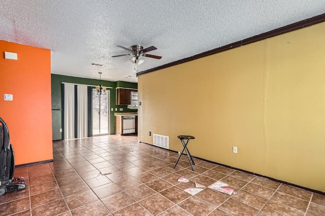 unfurnished room featuring ceiling fan, dark tile patterned floors, a textured ceiling, and ornamental molding