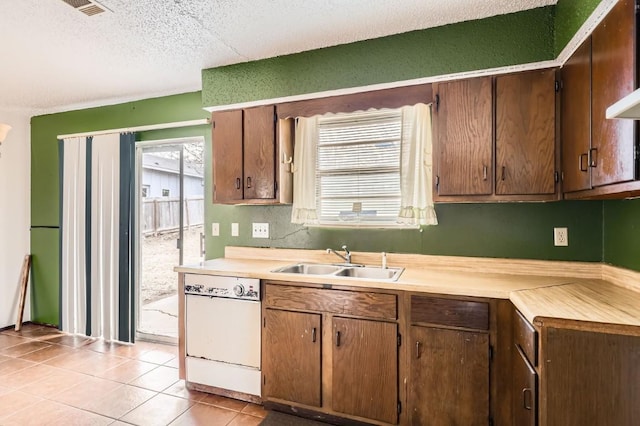 kitchen with dishwasher, light tile patterned floors, a textured ceiling, and sink