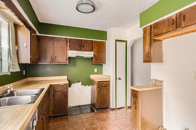 kitchen with light tile patterned floors, a textured ceiling, and sink