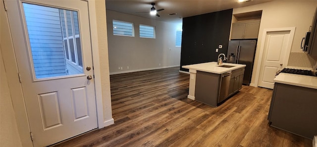 kitchen with stainless steel fridge, dark hardwood / wood-style flooring, a kitchen island with sink, and ceiling fan