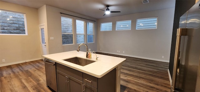 kitchen featuring dark wood-type flooring, a kitchen island with sink, sink, ceiling fan, and stainless steel appliances