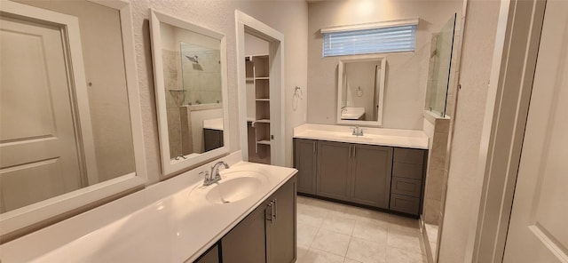 bathroom with tile patterned flooring, vanity, and tiled shower