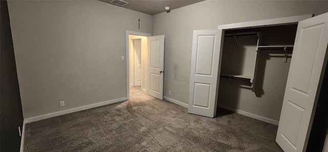 unfurnished bedroom with dark colored carpet and a closet