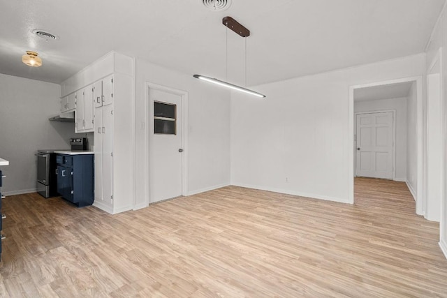 interior space with light wood-type flooring, blue cabinets, pendant lighting, white cabinets, and stainless steel electric range oven