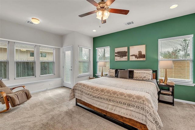 carpeted bedroom featuring ceiling fan and multiple windows