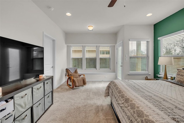 bedroom featuring multiple windows, light colored carpet, and ceiling fan