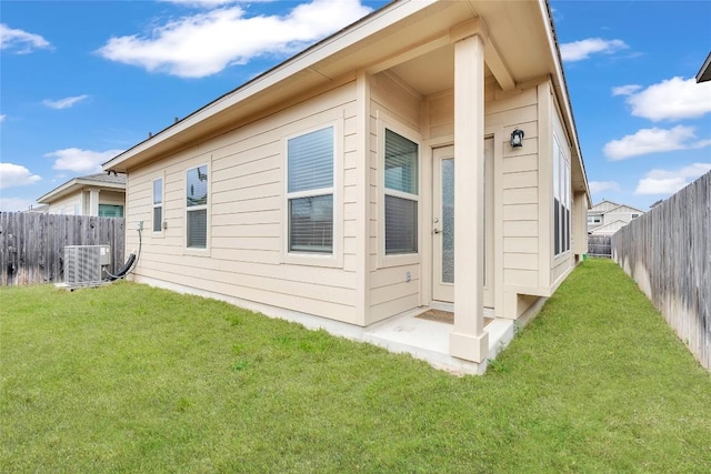 view of side of property with a lawn and central AC