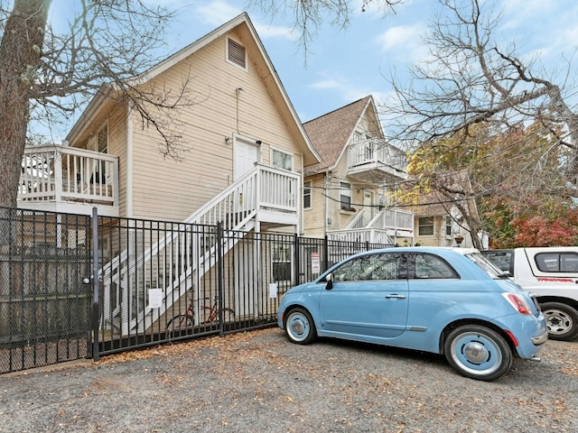 view of side of property with stairway and fence