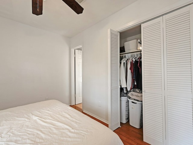 bedroom with ceiling fan, a closet, and dark hardwood / wood-style floors