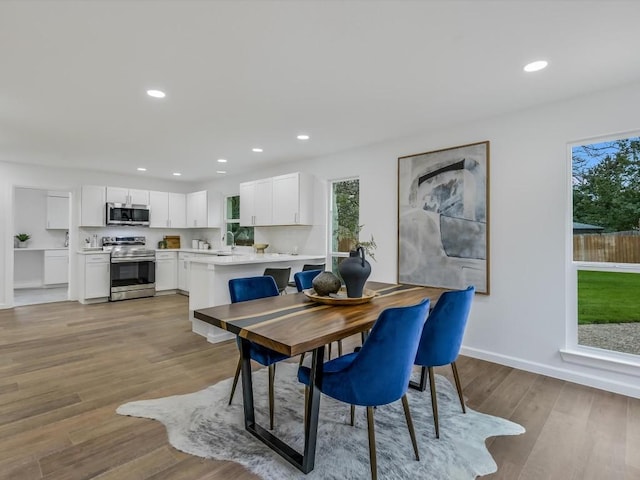 dining area featuring light wood-type flooring and sink