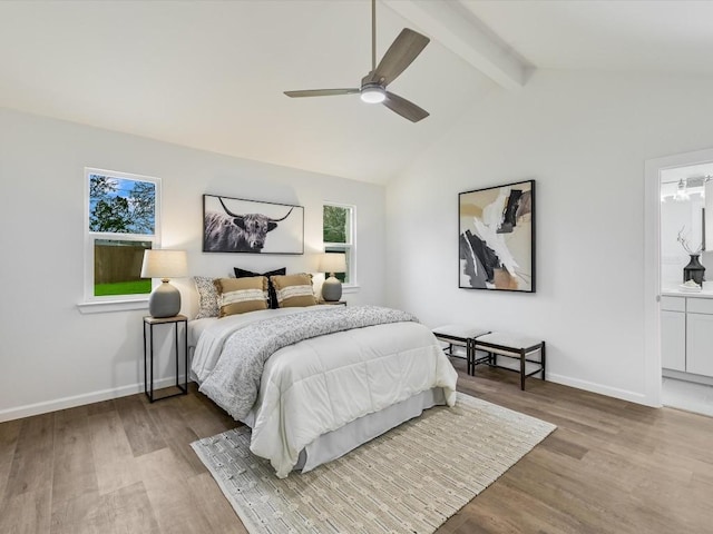 bedroom featuring vaulted ceiling with beams, ceiling fan, light wood-type flooring, and ensuite bath