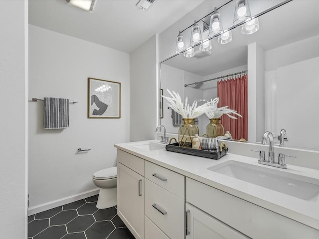 bathroom featuring tile patterned flooring, vanity, and toilet