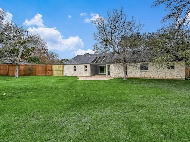 back of house featuring a lawn and a patio area