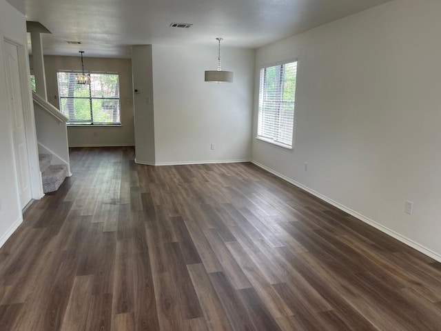 interior space featuring dark hardwood / wood-style flooring, an inviting chandelier, and a healthy amount of sunlight