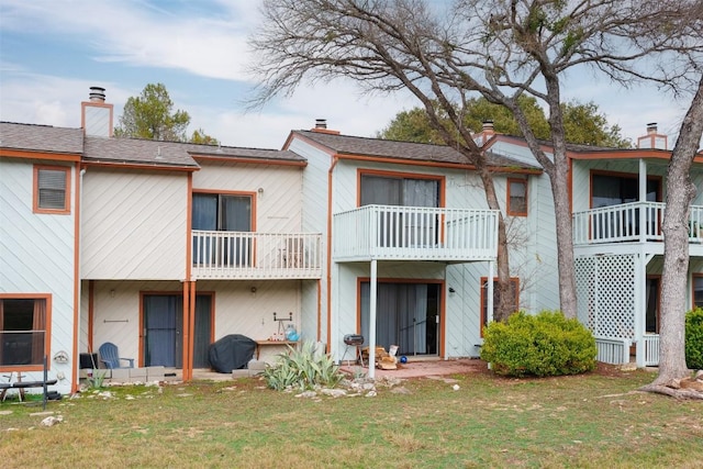 rear view of property featuring a lawn