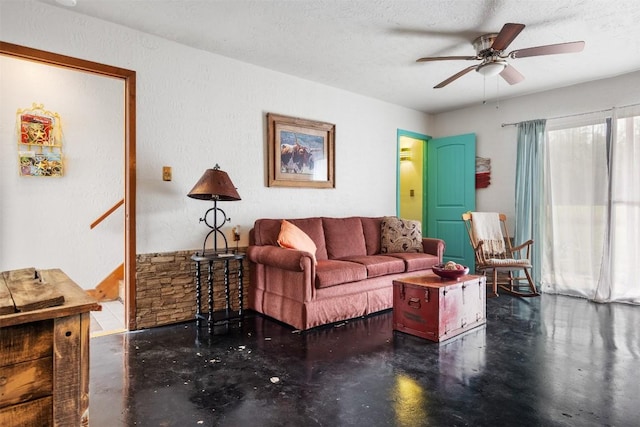 living room with ceiling fan and a textured ceiling