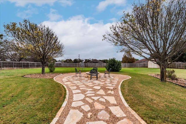 view of property's community with a patio, an outdoor fire pit, a fenced backyard, an outdoor structure, and a yard