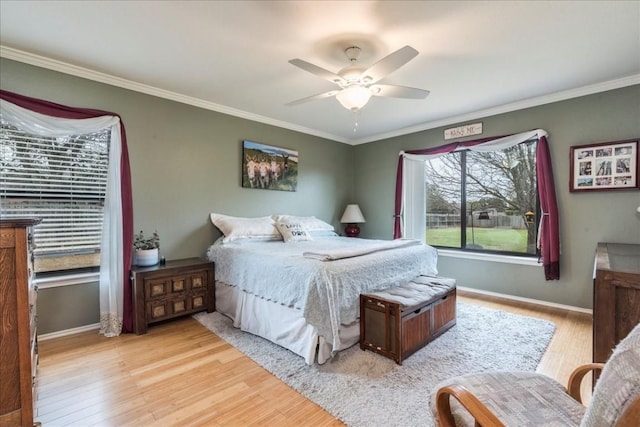 bedroom featuring baseboards, crown molding, and light wood finished floors