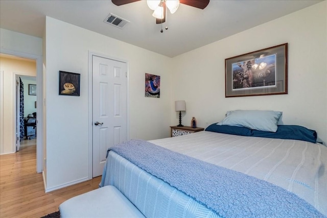 bedroom featuring ceiling fan, light wood finished floors, and visible vents