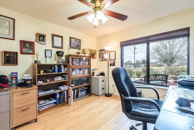 home office with light wood-style floors and ceiling fan