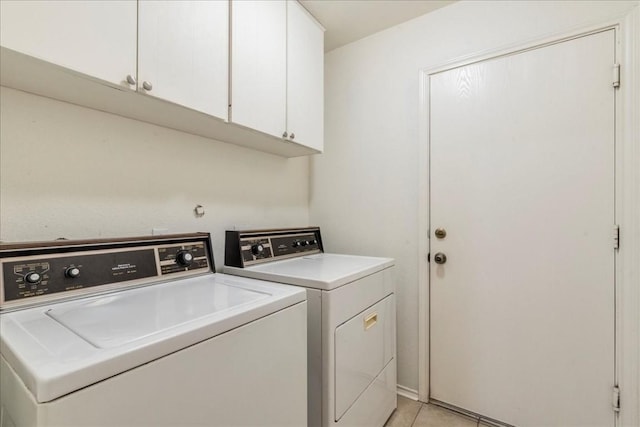 laundry room featuring separate washer and dryer, light tile patterned flooring, and cabinet space