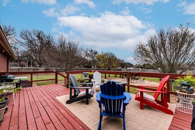 wooden terrace featuring a lawn and a fenced backyard