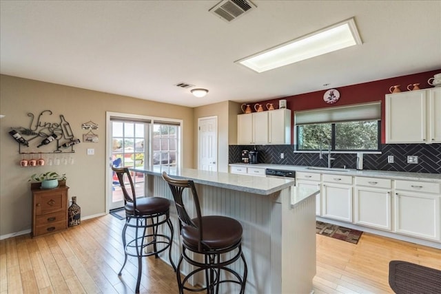 kitchen featuring plenty of natural light, light wood-style flooring, a kitchen bar, and a kitchen island