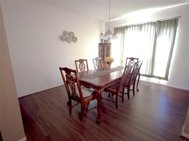 dining space with a chandelier and dark hardwood / wood-style flooring