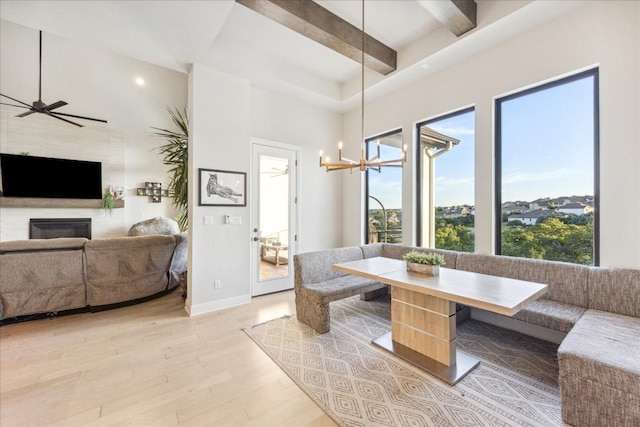 dining space with beamed ceiling, ceiling fan with notable chandelier, light hardwood / wood-style flooring, and breakfast area