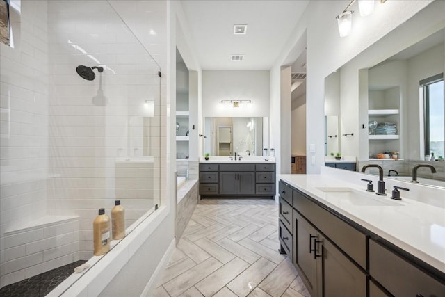 bathroom with built in shelves, vanity, and walk in shower