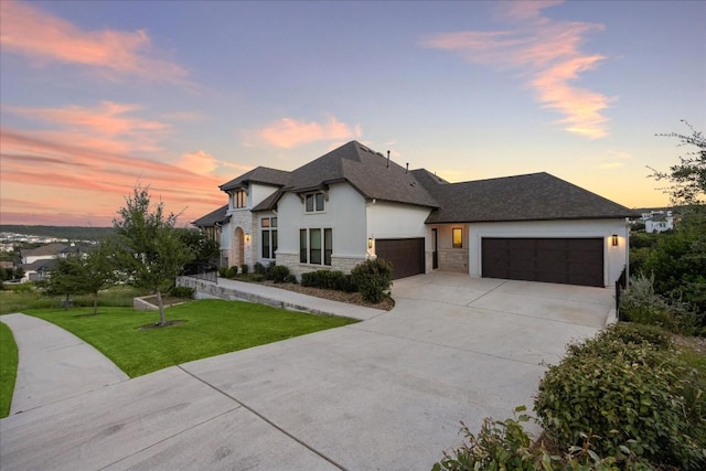 view of front of property with a garage and a yard